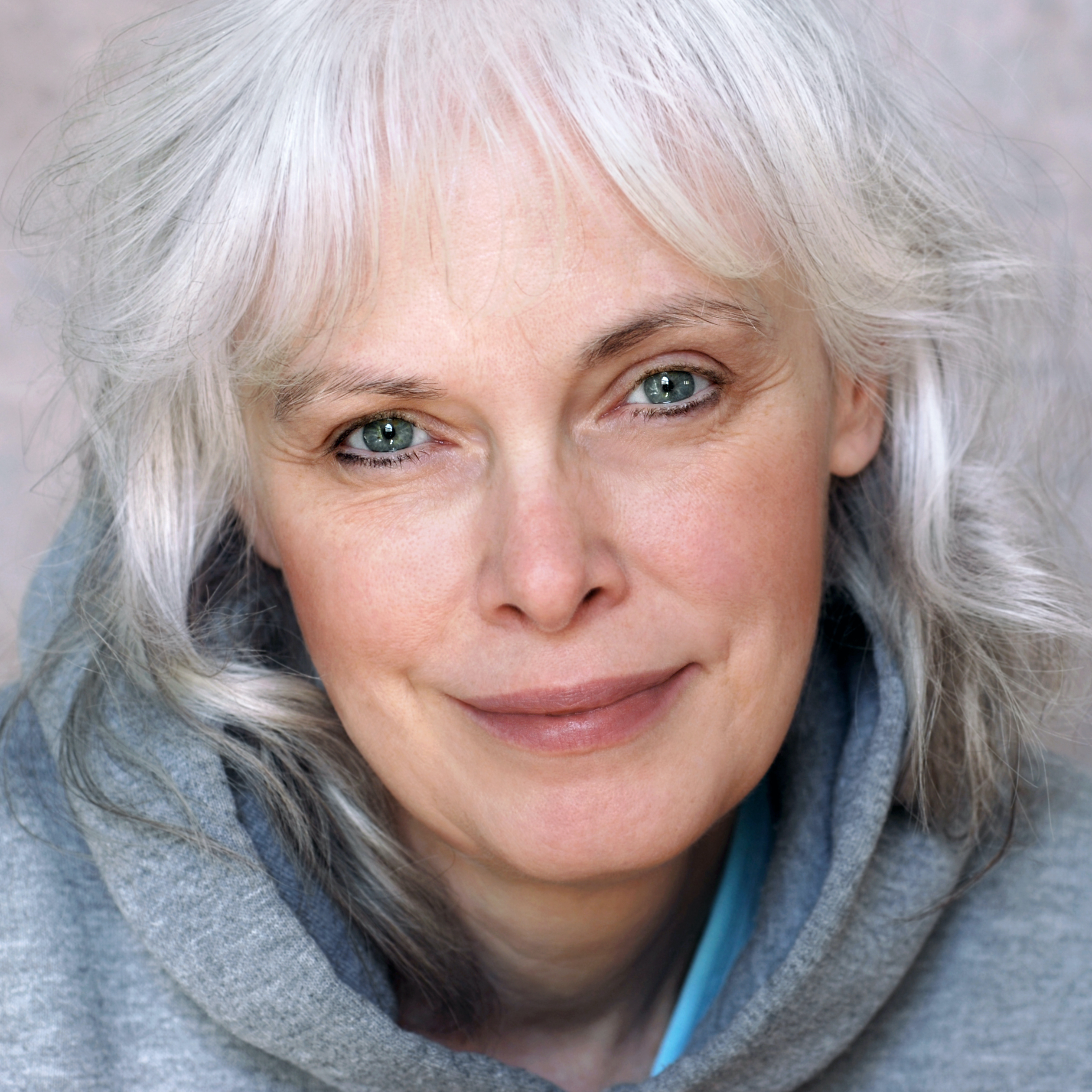 n with natural white hair and minimal makeup.